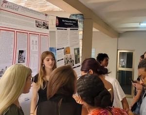 Caleigh Pfalzer discussing her research with a poster of data